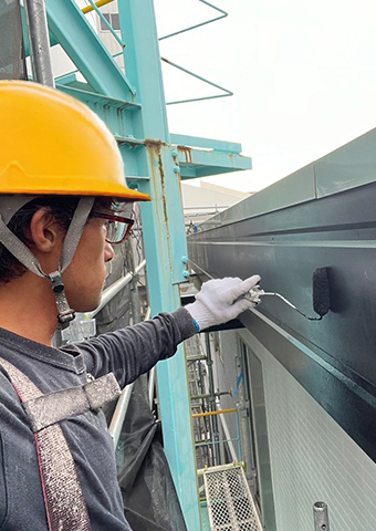 職人が刷毛で細かい塗装作業を行っている。