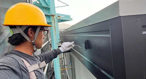 職人が刷毛で細かい塗装作業を行っている。